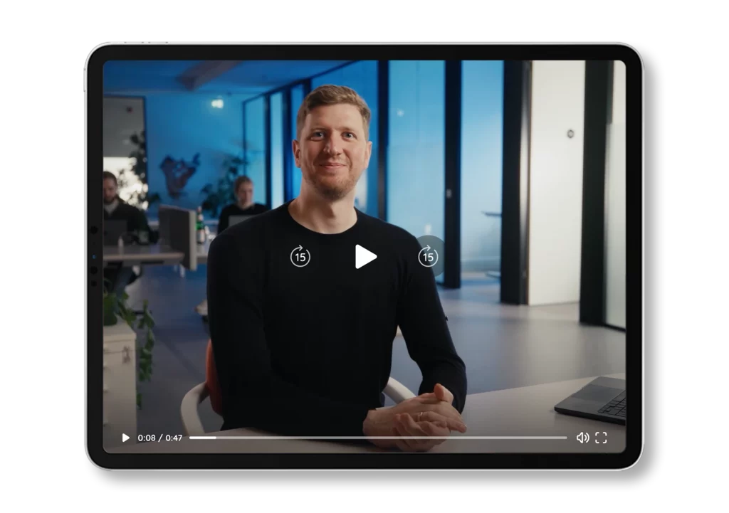 iPad-Mockup mit einem Video-Standbild von Kristof Peymann, der das Bärcare Preismodell in einem Büro erklärt.